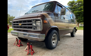 van in driveway with jackstands